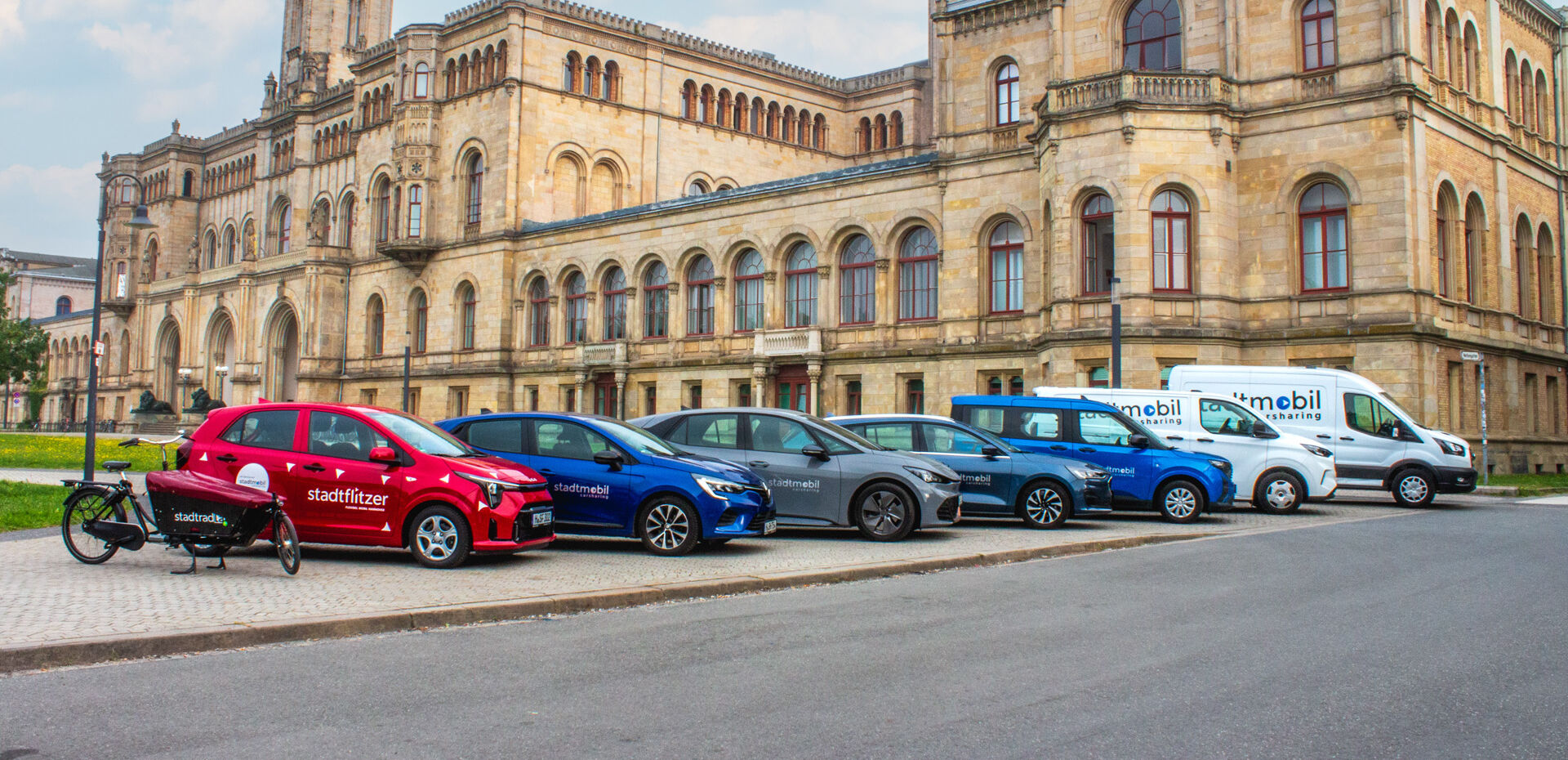 Fahrzeugflotte steht vor Unigebäude